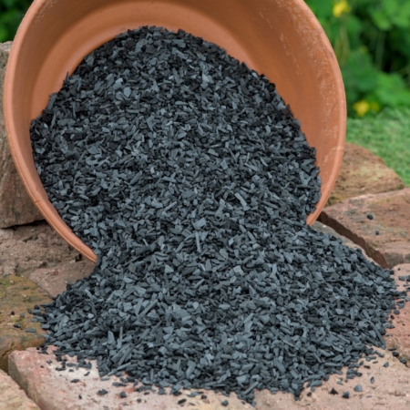 Premium Pflanzenkohle (Buchenkohle 3-5 mm) für Lophophora und Kakteen, wie sie aus einem Terrakottatopf auf Ziegelsteine geschüttet wird.